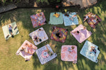 Image of people sitting or lying on Nakie's recycled picnic blankets in different colors, enjoying outdoor gatherings with comfort and sustainability. preview #2