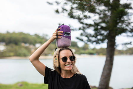 Convenient purple Nakie hammock folded and tucked into its included bag, perfect for camping, hiking, or beach outings.