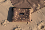 Brown recycled nylon pouch with celestial moon and sun pattern, black zipper and NAKIE brand label, displayed on sand. preview #7