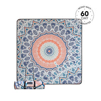 Recycled picnic blanket with coral and navy mandala design, featuring geometric patterns and rolled carrying strap